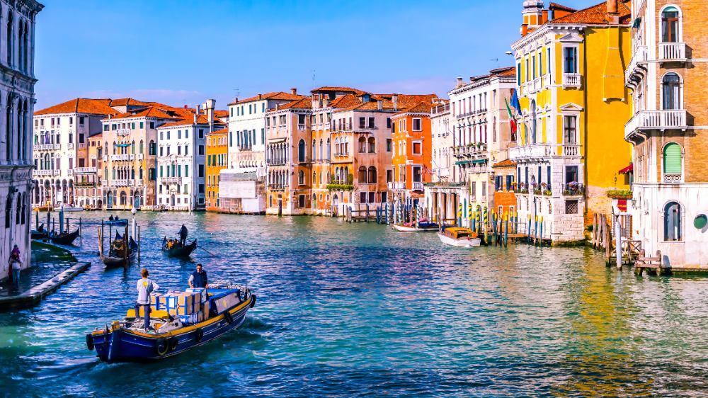 A boat floating down the canals in Venice, surrounded by historical buildings